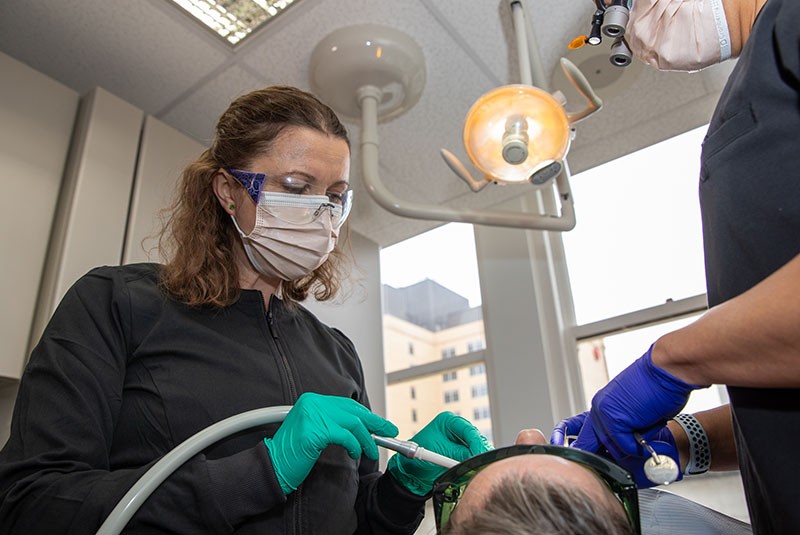 Staff member performing guided dental procedure on patient